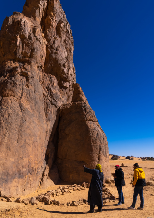 Tourists visiting la vache qui pleure rock carving, North Africa, Erg Admer, Algeria