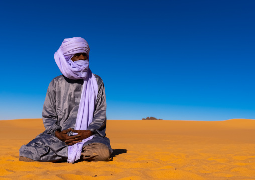 Tuareg sit in the Sahara desert, North Africa, Erg Admer, Algeria