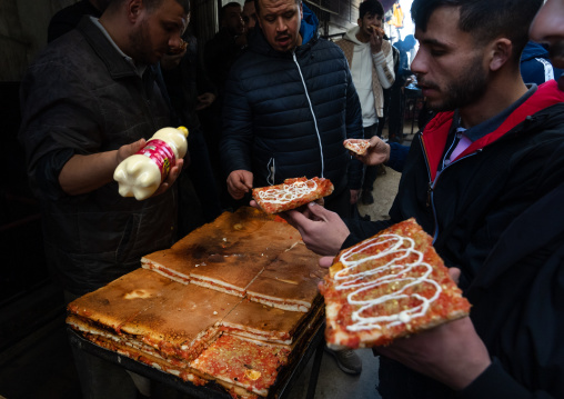 Algerian people buying pizzas in Souk El Ghezel, North Africa, Constantine, Algeria