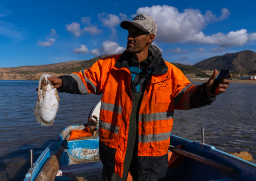 Fisherman with cuttlefish in Madagh beach, North Africa, Oran, Algeria