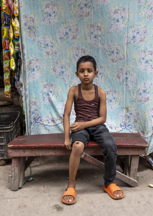 Bangladeshi boy sit on a bench in Korail slum, Dhaka Division, Dhaka, Bangladesh