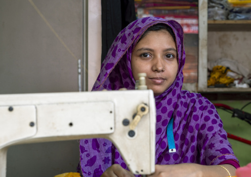 Teenage girl working on a sewing machine in Korail slum, Dhaka Division, Dhaka, Bangladesh