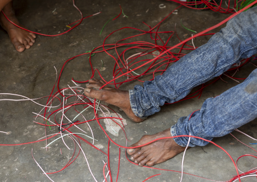 Bangladeshi man dismantling scrap cables and wires for recycling, Dhaka Division, Dhaka, Bangladesh