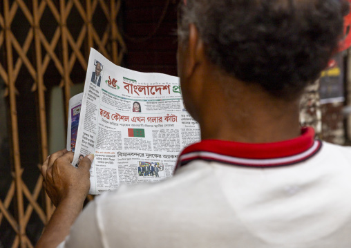 Bangladeshi man reading newspaper in the street, Dhaka Division, Dhaka, Bangladesh