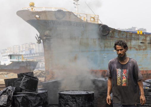 Bangladeshi man burning asphalt at Dhaka Shipyard, Dhaka Division, Keraniganj, Bangladesh