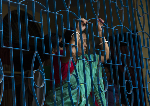 Manipuri tribe woman behind a house metalic fence, Sylhet Division, Sreemangal, Bangladesh