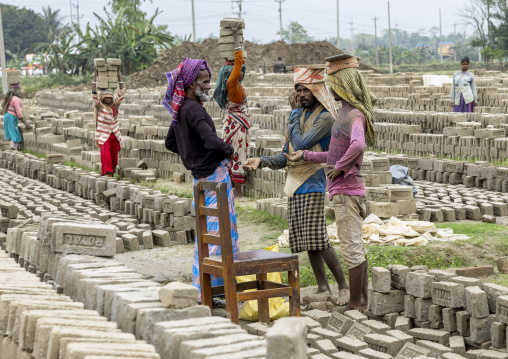 Supervisor paying a workers at a brick factory, Sylhet Division, Bahubal, Bangladesh