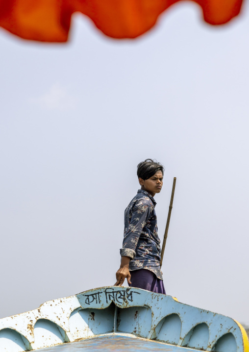 Bangladeshi man with a long stick on a boat in Sundarbans, Barisal Division, Wazirpur, Bangladesh