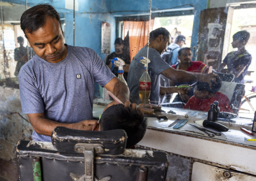 Hairdresser cutting boy hair, Rajshahi Division, Puthia, Bangladesh