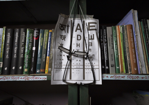 Reading glasses on display and eyesight test chart at a library, Rajshahi Division, Manda, Bangladesh