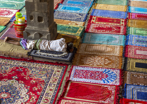 Bangladeshi man sleeping on carpets inside Kusumba mosque, Naogaon District, Manda Upazila, Bangladesh