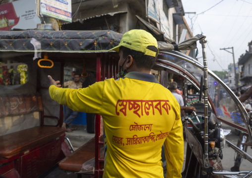 Bangladeshi municipality worker regulating traffic in the street, Rajshahi Division, Sariakandi, Bangladesh