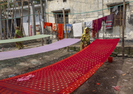 Bangladeshi workers putting wax on fabric, Dhaka Division, Rupganj, Bangladesh