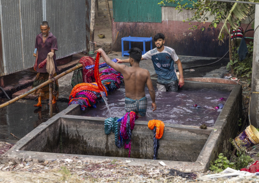 Bangladeshi men dyeing fabrics in tanks, Dhaka Division, Rupganj, Bangladesh