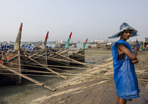 A bangladeshi porter waiting work at the morning fish market, Chittagong Division, Chittagong, Bangladesh