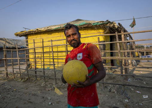 Bangladeshi man with a Bangladesh football shirt and a yellow ball, Chittagong Division, Cox's Bazar Sadar, Bangladesh