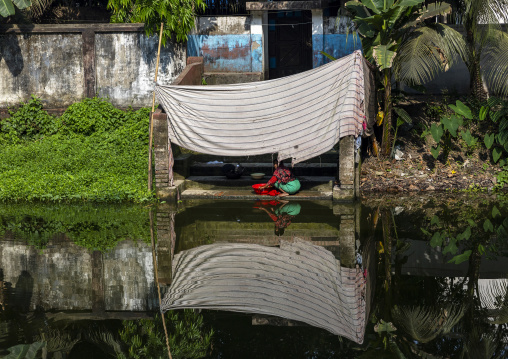 Woman washing clothes in a pond, Dhaka Division, Munshiganj Sadar, Bangladesh