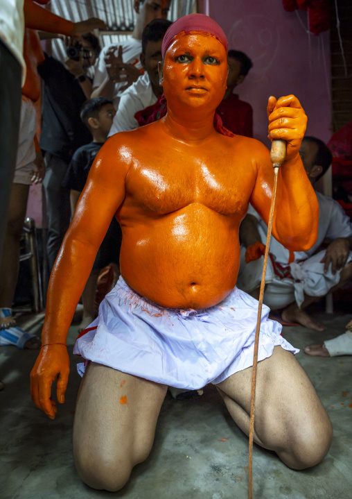 Hindu devotee with a sword covered with orange color at Lal Kach festival, Dhaka Division, Munshiganj Sadar, Bangladesh