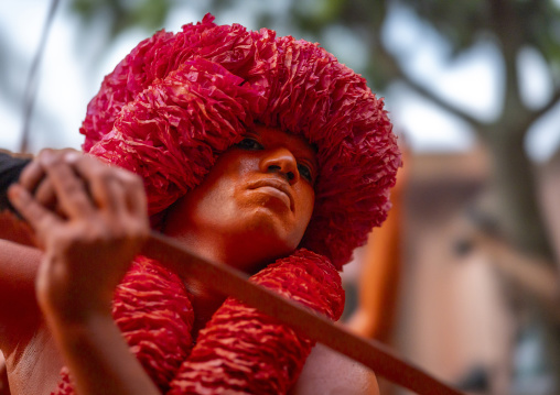 Hindu devotee with a sword covered with orange color at Lal Kach festival, Dhaka Division, Munshiganj Sadar, Bangladesh