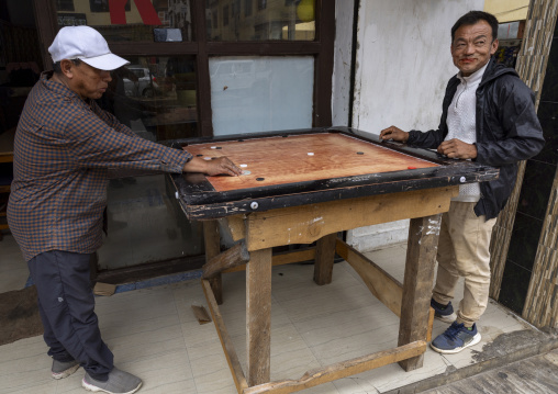 Bhutanese men playing a table game, Thedtsho Gewog, Wangdue Phodrang, Bhutan