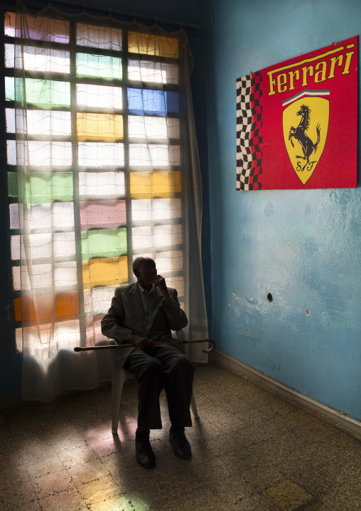 Old man in front of ferrari poster in the swimming pool, Central Region, Asmara, Eritrea