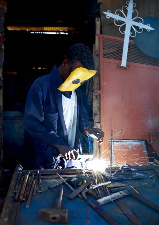 Eritrean man making Orthodox crosses in Medebar metal market, Central Region, Asmara, Eritrea