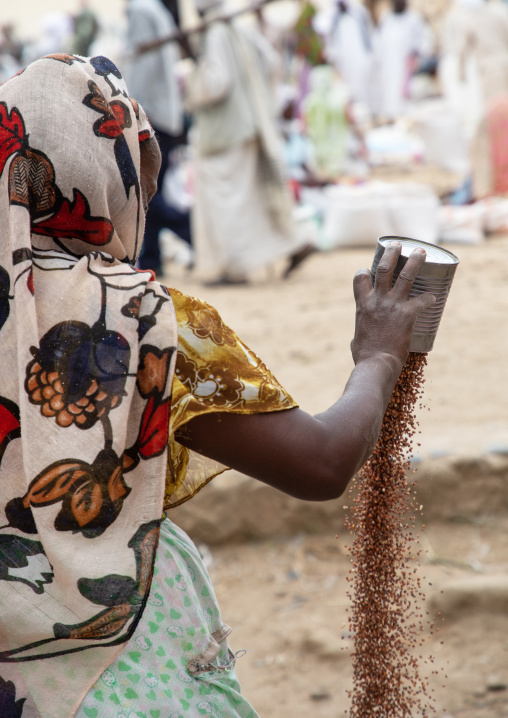 Eritrean woman sleving teff in the street, Semien-Keih-Bahri, Keren, Eritrea