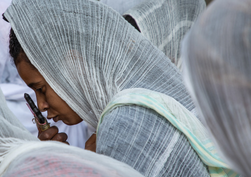 Eritrean women kissing the cross of a priest in enda mariam orthodox cathedral, Central region, Asmara, Eritrea