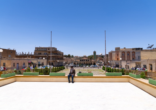 Eritrean man sit on the Grand mosque kulafa al rashidin esplanade, Central Region, Asmara, Eritrea