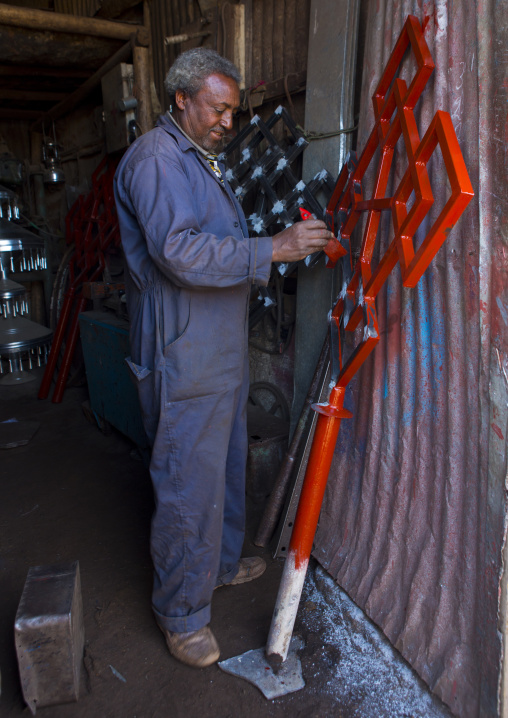 Man painting a red cross in medebar metal market, Central Region, Asmara, Eritrea