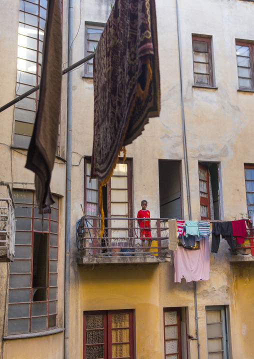 Eritrean boy on a Falletta art deco building balcony, Central Region, Asmara, Eritrea