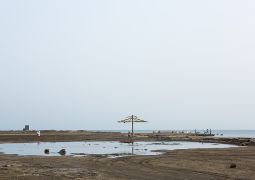 Umbrella on the seaside where old houses have been demolished, Northern Red Sea, Massawa, Eritrea