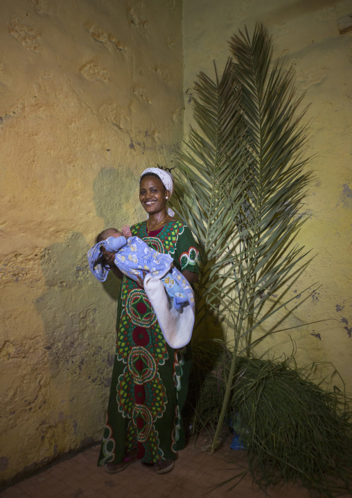 Eritrean mother holding her baby for baptism celebration, Northern Red Sea, Massawa, Eritrea