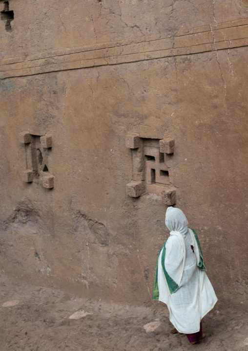 Ethiopian woman pilgrim praying in a rock-hewn church, Amhara Region, Lalibela, Ethiopia