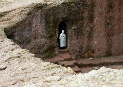 Ethiopian woman pilgrim praying in a rock-hewn church, Amhara Region, Lalibela, Ethiopia