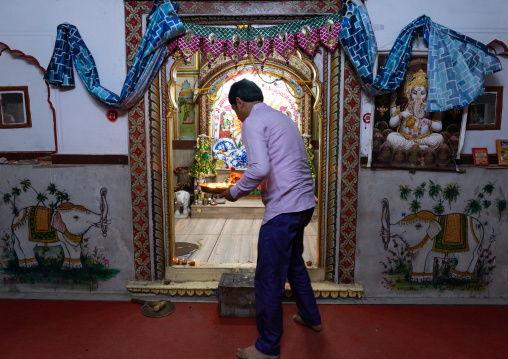 Indian man offering candles in a temple for Diwali, Rajasthan, Jaipur, India