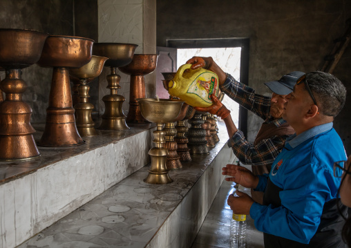 Pilgrims putting oil in oil lmaps in Shey Monastery, Ladakh, Shey, India