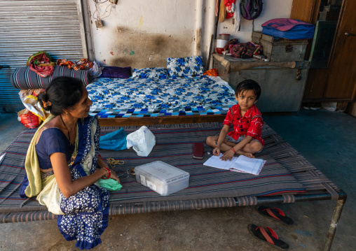 Child making his school exercices with his mother in old Delhi, Delhi, New Delhi, India