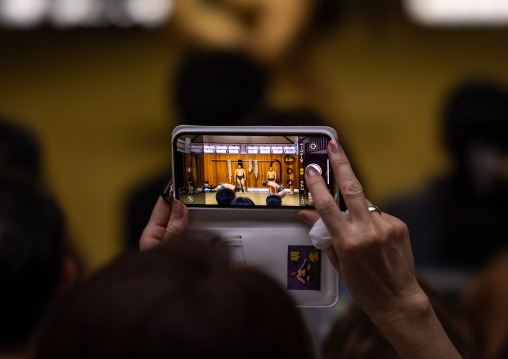 Tourist taking pictures with mobile phone in Tatsunami Beya sumo stable, Kanto region, Tokyo, Japan