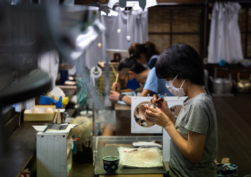 Artisans painting in Genemongama porcelain atelier, Kyushu region, Arita, Japan