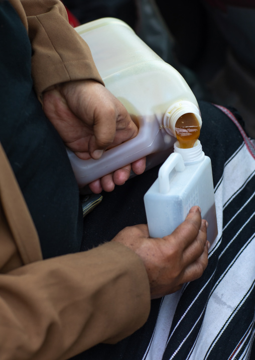 Saudi man transfering honey in a market, Jazan province, Addayer, Saudi Arabia