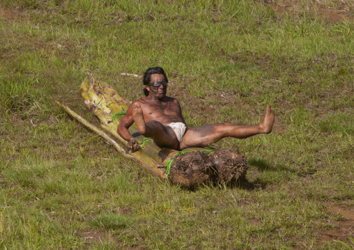 Man on banana trunk during haka pei competition during tapati festival, Easter Island, Hanga Roa, Chile