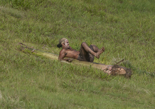 Man on banana trunk during haka pei competition during tapati festival, Easter Island, Hanga Roa, Chile