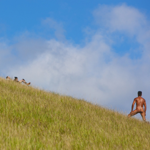 Man on banana trunk during haka pei competition during tapati festival, Easter Island, Hanga Roa, Chile