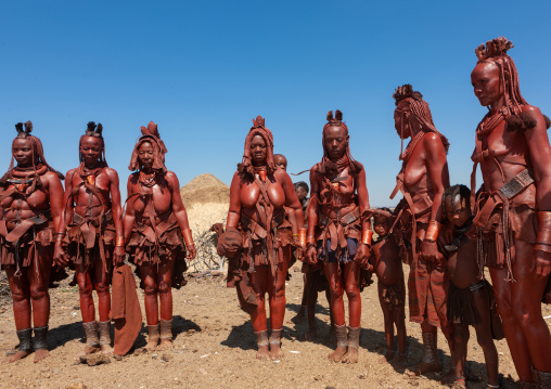 Himba tribe women covered with otjize standing in line, Cunene Province, Oncocua, Angola