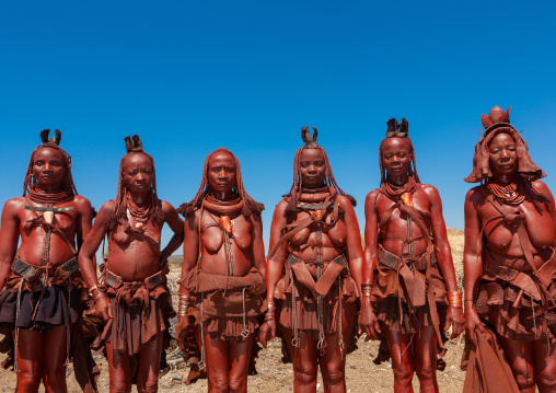 Himba tribe women covered with otjize standing in line, Cunene Province, Oncocua, Angola