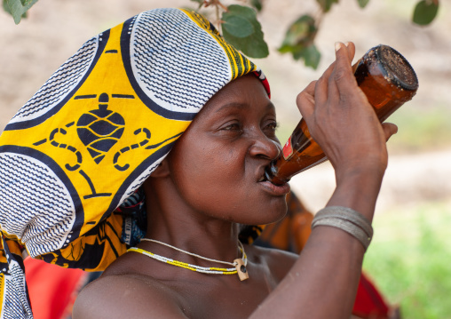 Mucubal tribe woman drinking a beer, Namibe Province, Virei, Angola