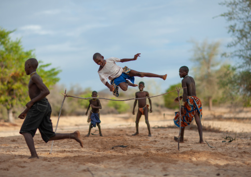 Mucubal tribe boys doing high jumping in the bush, Namibe Province, Virei, Angola