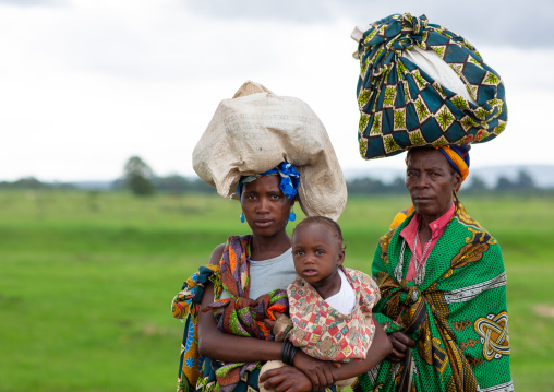 Women walking carrying sacks on head, Huila Province, Chibia, Angola