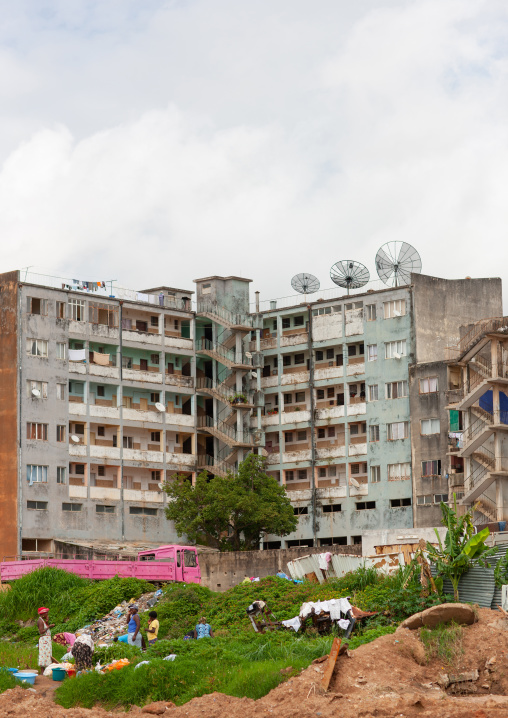 Women doing the laundry in basins in front of a housing building, Huambo Province, Huambo, Angola